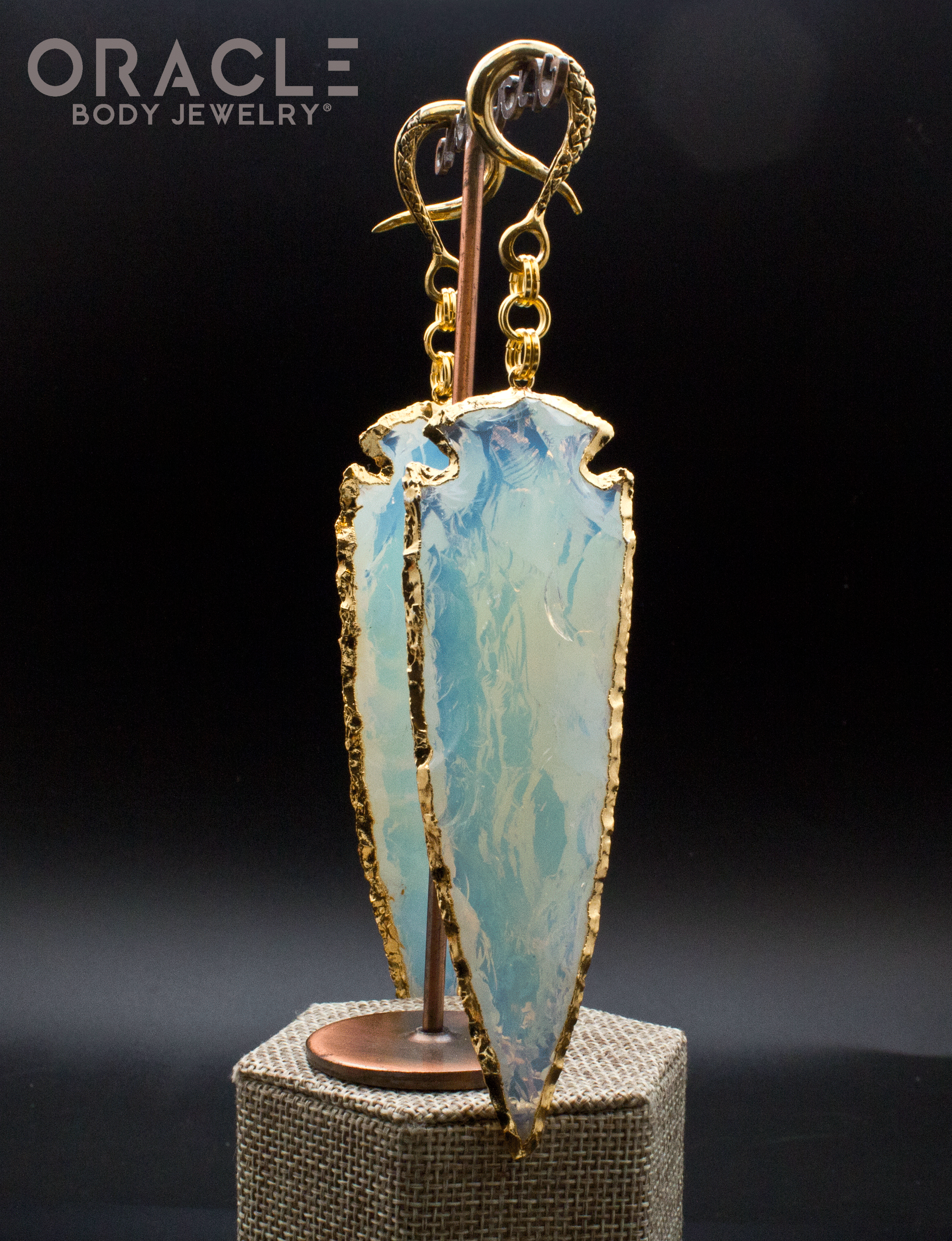 a hanging view of the opalite arrowhead jewelry showing a warm glow 